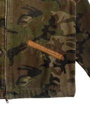 製品画像
「カモフラージュ柄とパッチワークデザインを組み合わせたクラシックなデトロイトジャケット。コットン100%の耐久性と快適性を兼ね備えたキャンバス生地で、ワークウェアスタイルにモダンなエッセンスをプラス。」
詳細画像
「胸ポケットやカモフラージュ柄のパッチワークディテールが施されたコットン100%キャンバス生地のクローズアップ画像。開襟デザインとジッパー仕様が実用性とデザイン性を高めている。」