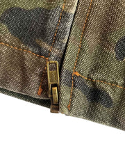 製品画像
「カモフラージュ柄とパッチワークデザインを組み合わせたクラシックなデトロイトジャケット。コットン100%の耐久性と快適性を兼ね備えたキャンバス生地で、ワークウェアスタイルにモダンなエッセンスをプラス。」
詳細画像
「胸ポケットやカモフラージュ柄のパッチワークディテールが施されたコットン100%キャンバス生地のクローズアップ画像。開襟デザインとジッパー仕様が実用性とデザイン性を高めている。」