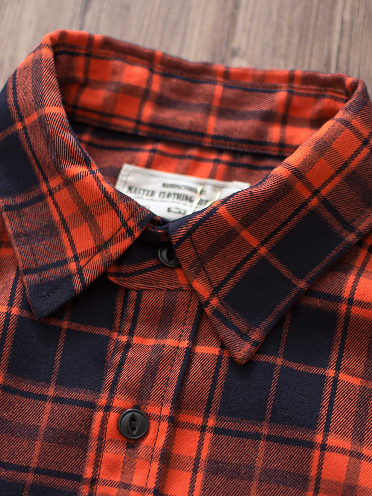 製品画像
「ヴィンテージ加工を施したチェック柄厚手シャツ全体のイメージ。クラシックなアメカジデザインと300gのTR混紡生地が特徴で、5色展開の豊富な選択肢を提供。」
詳細画像
「ツーポケットディテールとヴィンテージ加工チェック柄が施されたTR混紡生地のクローズアップ。滑らかな触感とフランネルのような暖かさを備えた300gの厚手素材。」