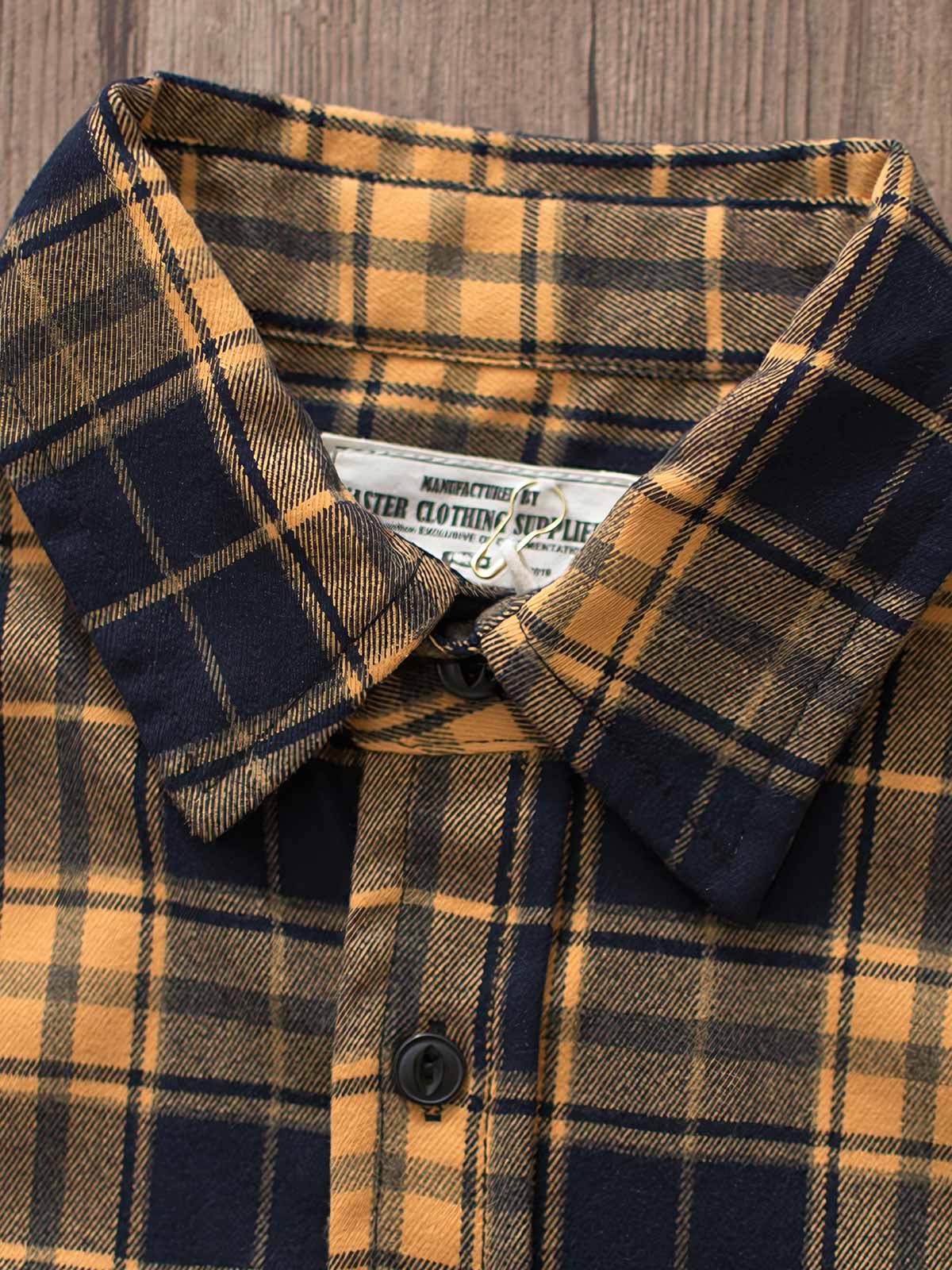 製品画像
「ヴィンテージ加工を施したチェック柄厚手シャツ全体のイメージ。クラシックなアメカジデザインと300gのTR混紡生地が特徴で、5色展開の豊富な選択肢を提供。」
詳細画像
「ツーポケットディテールとヴィンテージ加工チェック柄が施されたTR混紡生地のクローズアップ。滑らかな触感とフランネルのような暖かさを備えた300gの厚手素材。」