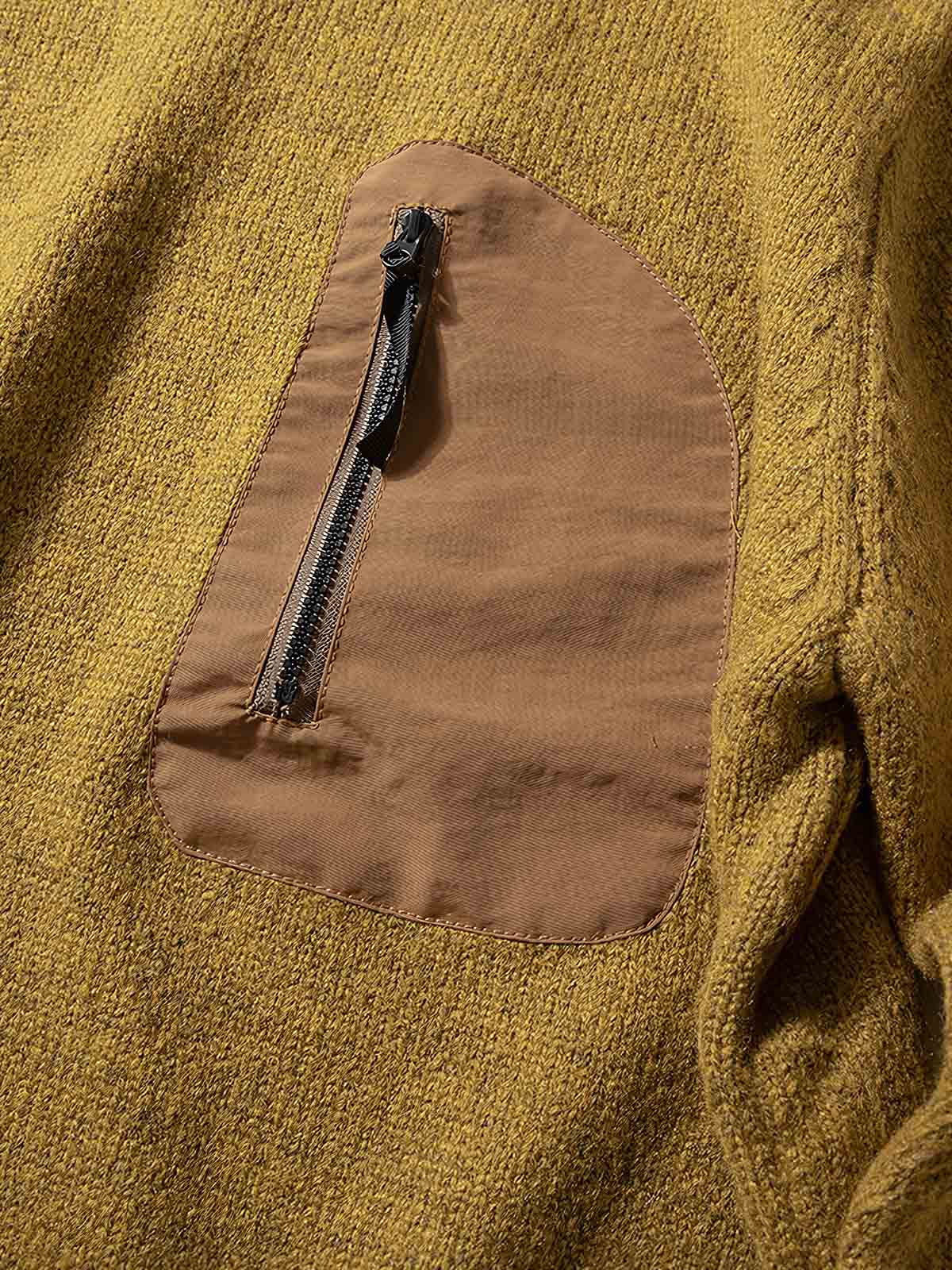 製品画像
「ウール混紡ニットセーター、バイカラー切り替えデザインと防水ナイロン裾、粗い五本針編みで重厚感を演出し、高い保温性を提供。ジッパーポケットと太めドローコードによる実用性と視覚的アクセントが特徴。」
詳細画像
「粗い五本針編みで編まれたウール混紡ニット、ジッパーポケットが胸元に配置され、防水ナイロン裾で耐久性と防水性を実現。裾の太めドローコードで調整可能なフィット感。」