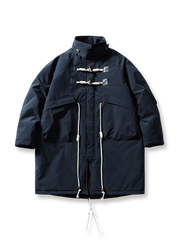 製品画像
牛角ボタン付きのロング丈中綿コート。クラシックなデザインと100%ナイロン素材による防風性が特徴で、高品質な中綿を使用した厚手の防寒コートの全体展示。冬のアウトドアや日常使いに最適。
詳細画像
牛角ボタンのディテールとドローコード付き立ち襟を特写。クラシックな雰囲気を醸し出すボタンデザインと、防寒性を高めるドローコードのディテールが際立つクローズアップ画像。