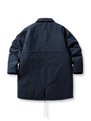 製品画像
牛角ボタン付きのロング丈中綿コート。クラシックなデザインと100%ナイロン素材による防風性が特徴で、高品質な中綿を使用した厚手の防寒コートの全体展示。冬のアウトドアや日常使いに最適。
詳細画像
牛角ボタンのディテールとドローコード付き立ち襟を特写。クラシックな雰囲気を醸し出すボタンデザインと、防寒性を高めるドローコードのディテールが際立つクローズアップ画像。