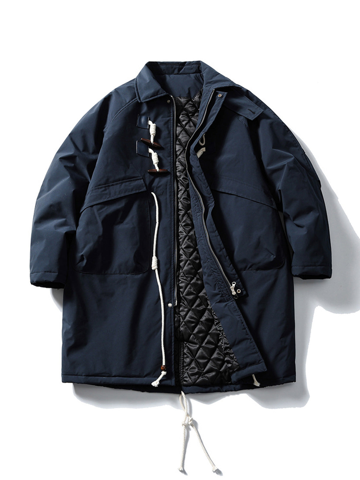 製品画像
牛角ボタン付きのロング丈中綿コート。クラシックなデザインと100%ナイロン素材による防風性が特徴で、高品質な中綿を使用した厚手の防寒コートの全体展示。冬のアウトドアや日常使いに最適。
詳細画像
牛角ボタンのディテールとドローコード付き立ち襟を特写。クラシックな雰囲気を醸し出すボタンデザインと、防寒性を高めるドローコードのディテールが際立つクローズアップ画像。