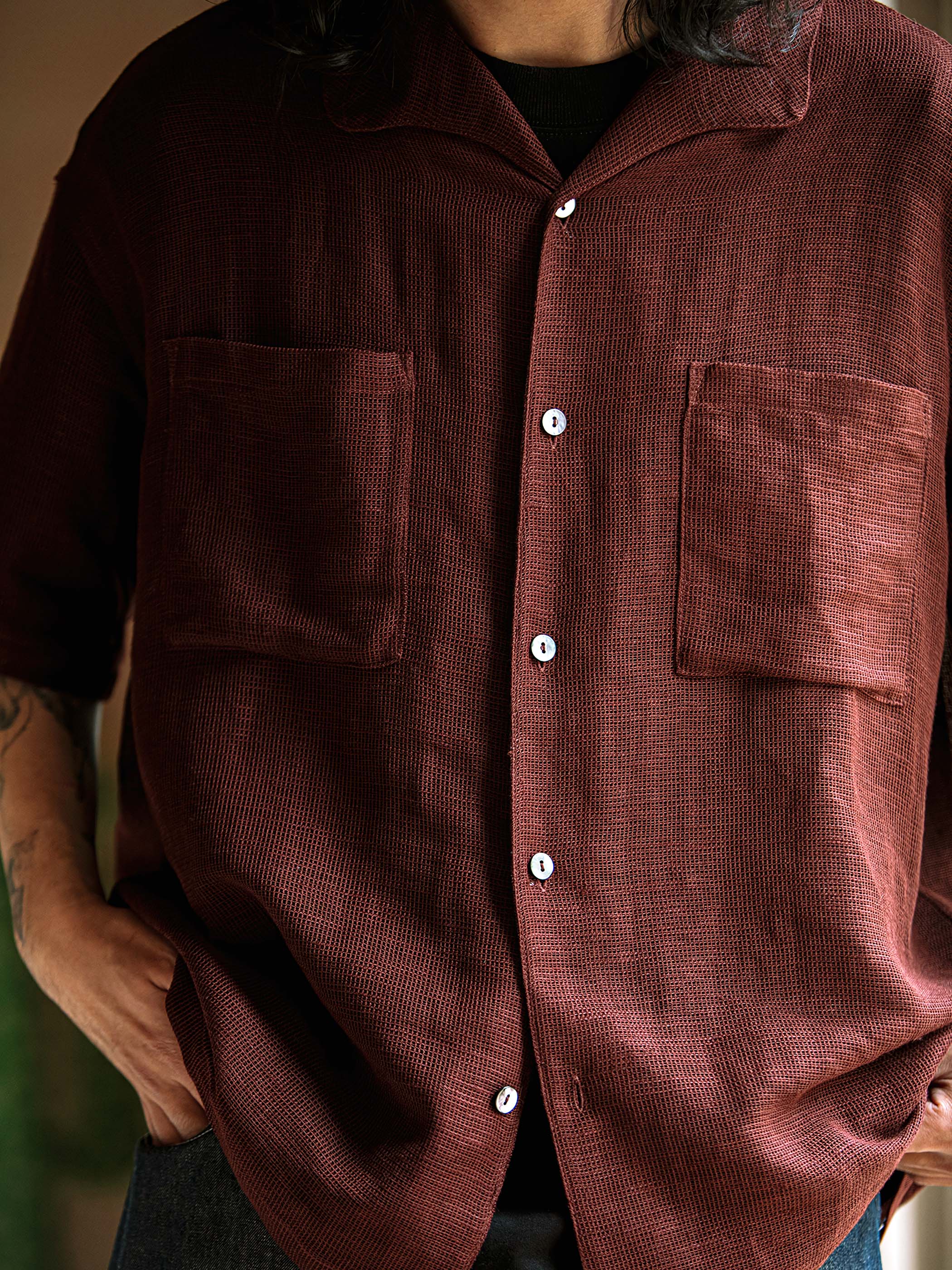 シャツの独特なメッシュ模様とウォッシュ加工、胸のポケットと裾のまっすぐなライン、背中のフリル装飾の詳細