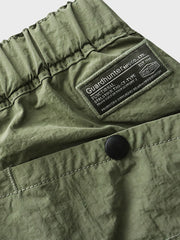 ショーツのゴム入りウエストベルトとバックルベルトの詳細。さまざまなポケットが配置され、機能性と実用性を追求したデザインが確認できます。