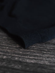 ポロシャツの高織り長繊維綿素材と天然貝殻ボタンのディテールを特集し、品質へのこだわりを示す。