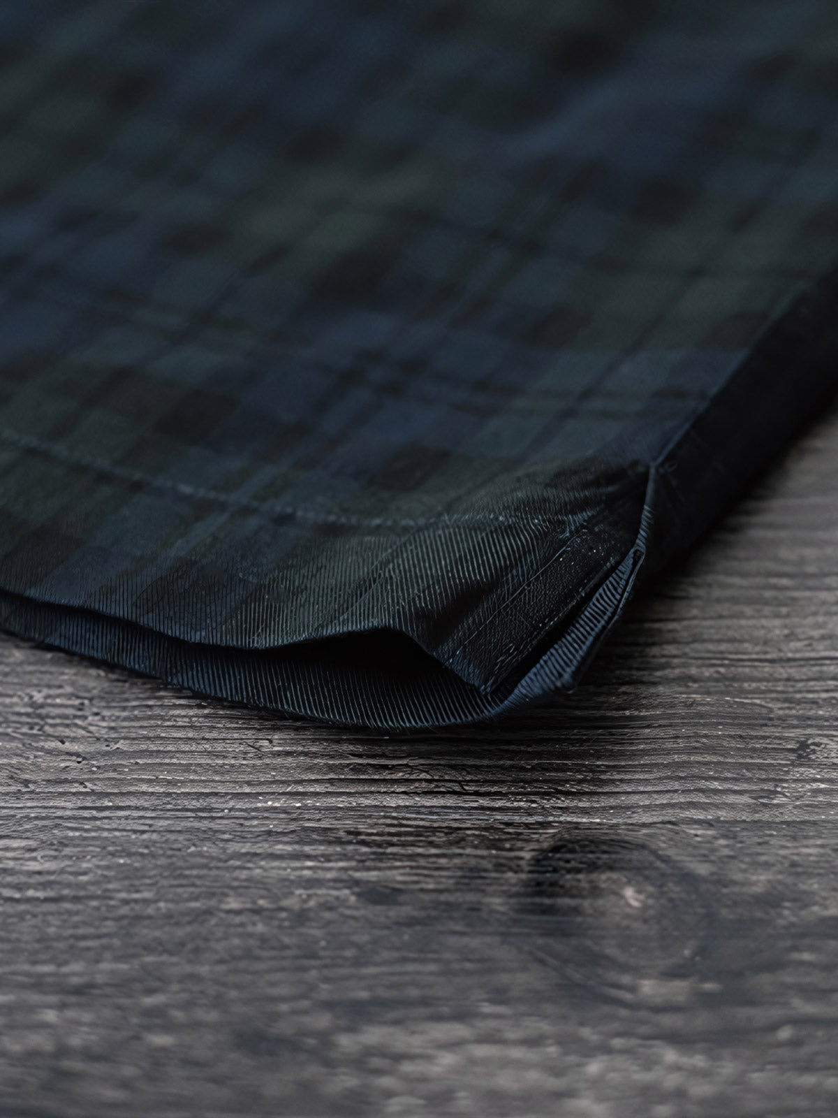 シャツのダークグリーン&ネイビーチェックのディテールとナチュラルキャッツアイボタンのクローズアップ