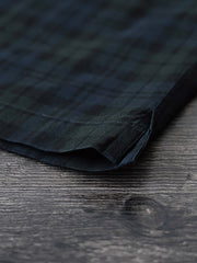 シャツのダークグリーン&ネイビーチェックのディテールとナチュラルキャッツアイボタンのクローズアップ