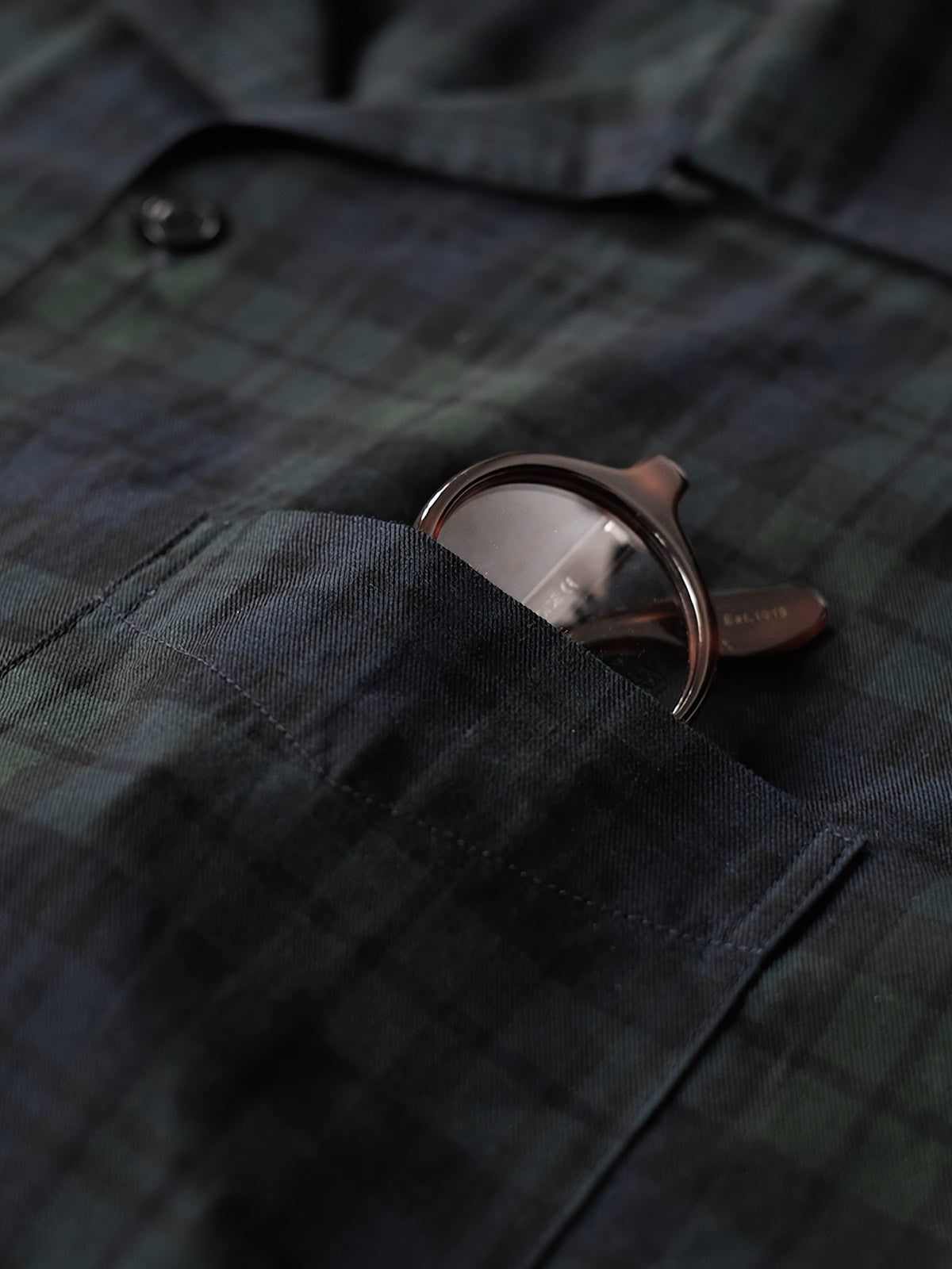 シャツのダークグリーン&ネイビーチェックのディテールとナチュラルキャッツアイボタンのクローズアップ