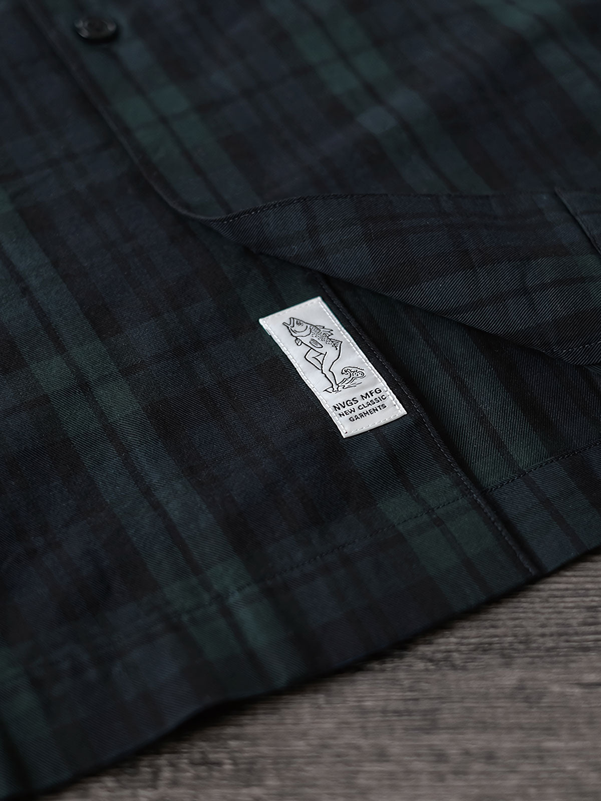 シャツのダークグリーン&ネイビーチェックのディテールとナチュラルキャッツアイボタンのクローズアップ