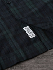 シャツのダークグリーン&ネイビーチェックのディテールとナチュラルキャッツアイボタンのクローズアップ
