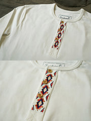 製品画像
クラシックな刺繍入りデザインの改良型ヴィンテージヘンリーネック 長袖Tシャツの正面全体画像。高品質なアメリカ産ピマコットン素材を使用した一着。
詳細画像
刺繍入りの近似色前立てとダブルステッチ仕上げ、リブ仕様の袖口ディテールをクローズアップした画像。美しい縫製と耐久性が特徴。