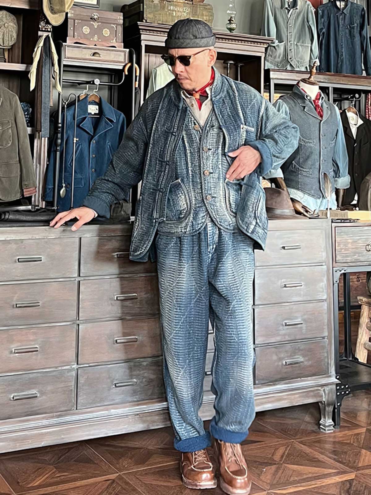 詳細画像: チャイナボタンのクラシックなディテールとストーンウォッシュ加工による深みのある藍色を強調した写真。
モデル画像: Indigo 藍染め スタンドカラーチャイナボタン コートを着用したモデルによる、洗練されたヴィンテージスタイルのコーディネート写真。