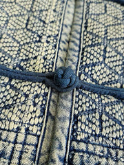 製品画像: 藍染め刺子織りピースワークスタンドカラージャケット全体写真。立ち襟とチャイナボタンが特徴の伝統とモダンが融合したデザイン。
詳細画像: 刺子織りの繊細なテクスチャと藍染めの深みある色合いを強調したディテール写真。水洗抜染加工による個性的な風合いを表現。