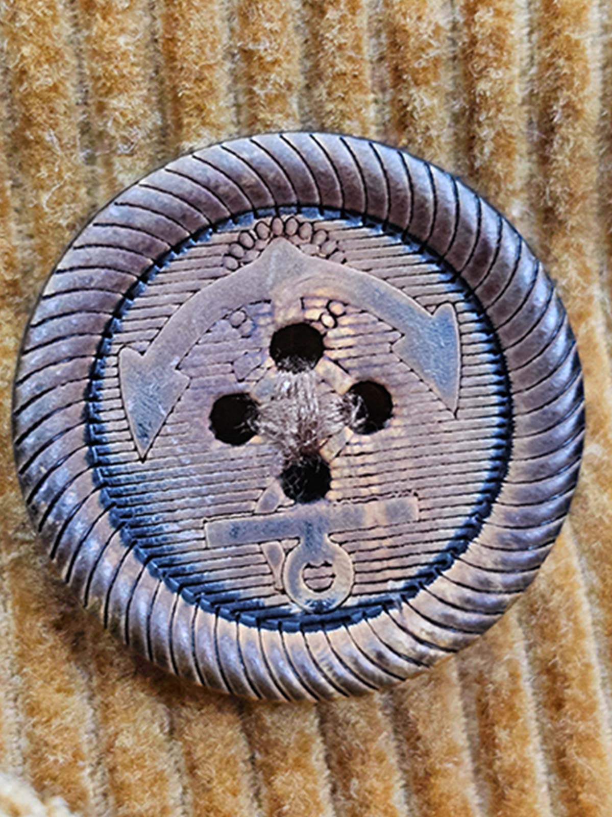 製品画像:アメリカンレトロスタイルのコーデュロイダブルブレストコートの正面図。厚手の生地で耐摩耗性に優れ、秋冬に最適。
詳細画像:ウシガシラボタンと本革で補強されたポケット口と袖口のディテール。アンカーデザインがレトロ感を引き立てます。