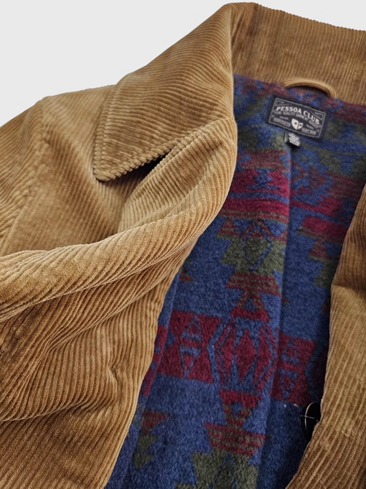 製品画像:アメリカンレトロスタイルのコーデュロイダブルブレストコートの正面図。厚手の生地で耐摩耗性に優れ、秋冬に最適。
詳細画像:ウシガシラボタンと本革で補強されたポケット口と袖口のディテール。アンカーデザインがレトロ感を引き立てます。