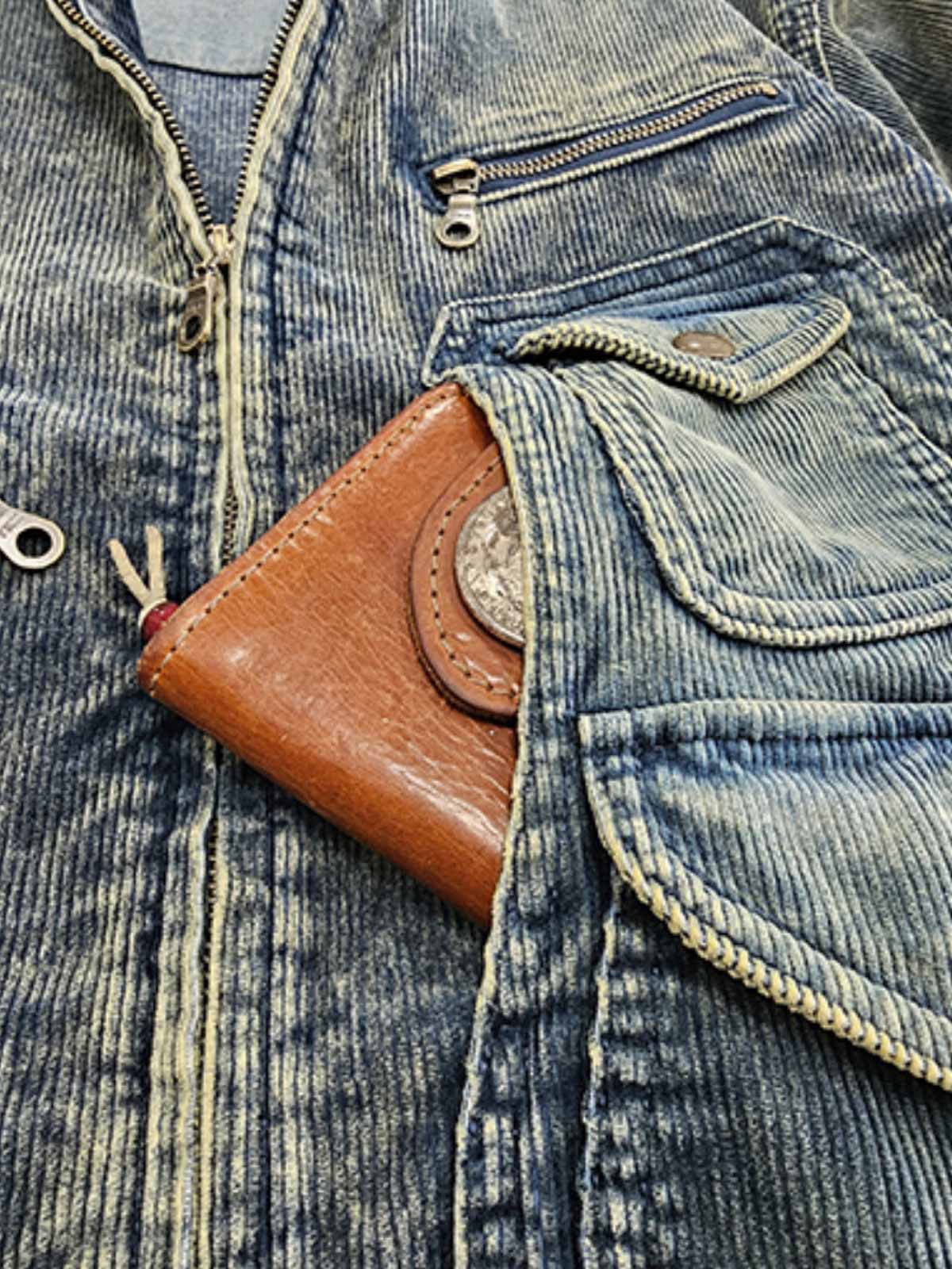 製品画像
タイダイ加工とヴィンテージ加工が特徴の多ポケット ワークジャケットの正面全体画像。100%コットン素材とショート丈デザインが際立つ個性的な一着。
詳細画像
YKK製の真鍮ジッパーとアンティーク調スナップボタン、多ポケットデザイン、そしてタイダイ加工の独特な風合いをクローズアップした画像。高級感とヴィンテージ感が融合したディテール。