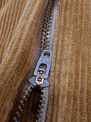 製品画像:アメリカンレトロスタイルのコーデュロイシングルプリーツロングパンツの正面図。クラシックで快適なデザインが特徴。
詳細画像:果実ボタンのユニークなディテールと、コーデュロイ素材の柔らかなテクスチャーを強調したクローズアップ画像。