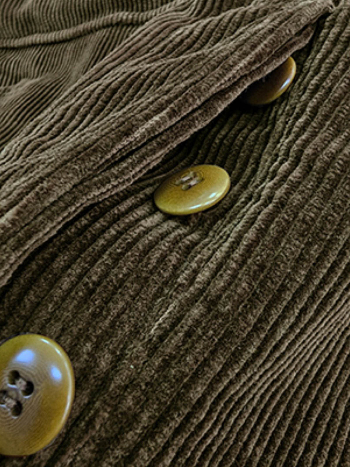 製品画像: コーデュロイハンティング多ポケットパンツ全体写真。高密度コーデュロイ素材とクラシックなハンティングデザインが特徴的なパンツ。
詳細画像: 厚手コーデュロイ素材の立体感とアンティーク加工の四合ボタン、ナッツボタンのディテールを強調した写真。