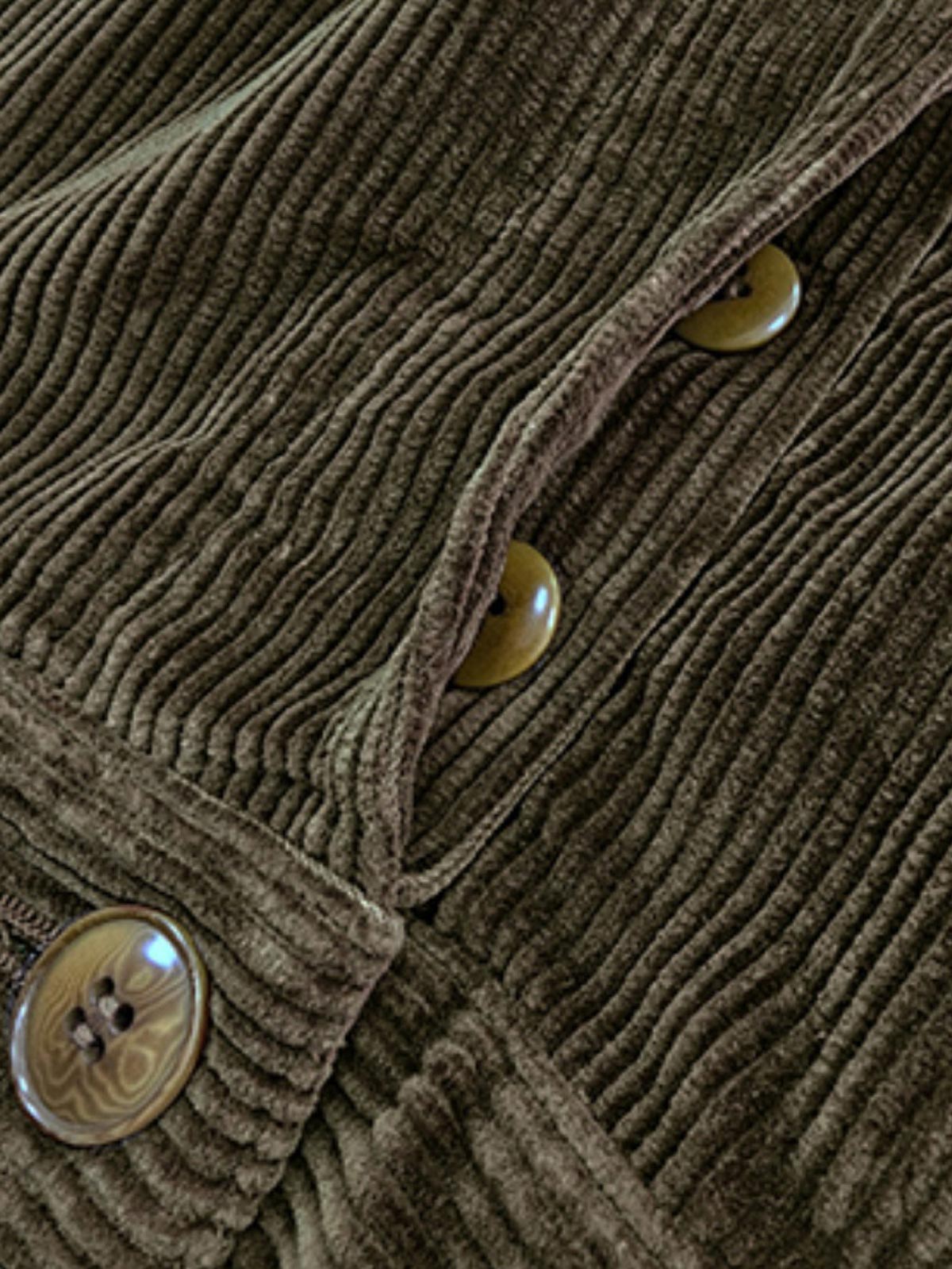 製品画像: コーデュロイハンティング多ポケットパンツ全体写真。高密度コーデュロイ素材とクラシックなハンティングデザインが特徴的なパンツ。
詳細画像: 厚手コーデュロイ素材の立体感とアンティーク加工の四合ボタン、ナッツボタンのディテールを強調した写真。