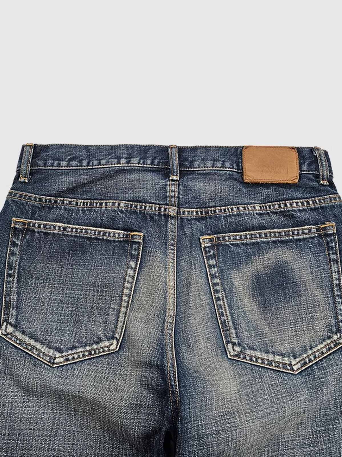 製品画像:アメカジ風の抜染加工ストレートデニムパンツの正面展示。100%コットン素材で、ウォッシュ加工と自然なヒゲデザインが特徴のヴィンテージスタイルのデニムパンツ。
詳細画像:抜染加工による色落ちと、クラシックなアメカジ風のヒゲデザインのディテールをクローズアップ。日系デニムの高い耐久性と美しい経年変化を表現。