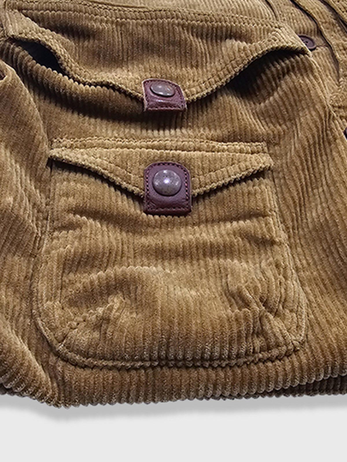 製品画像
多ポケット コーデュロイ ハンティング ベストの正面全体画像。クラシックなアメカジスタイルと100%コットン素材による耐久性が特徴の一着。
詳細画像
バーナー仕上げの天然牛角ボタン、多機能ポケット、アンティーク加工の金属スナップボタンのディテールをクローズアップした画像。上質感と実用性を強調した仕上がり。