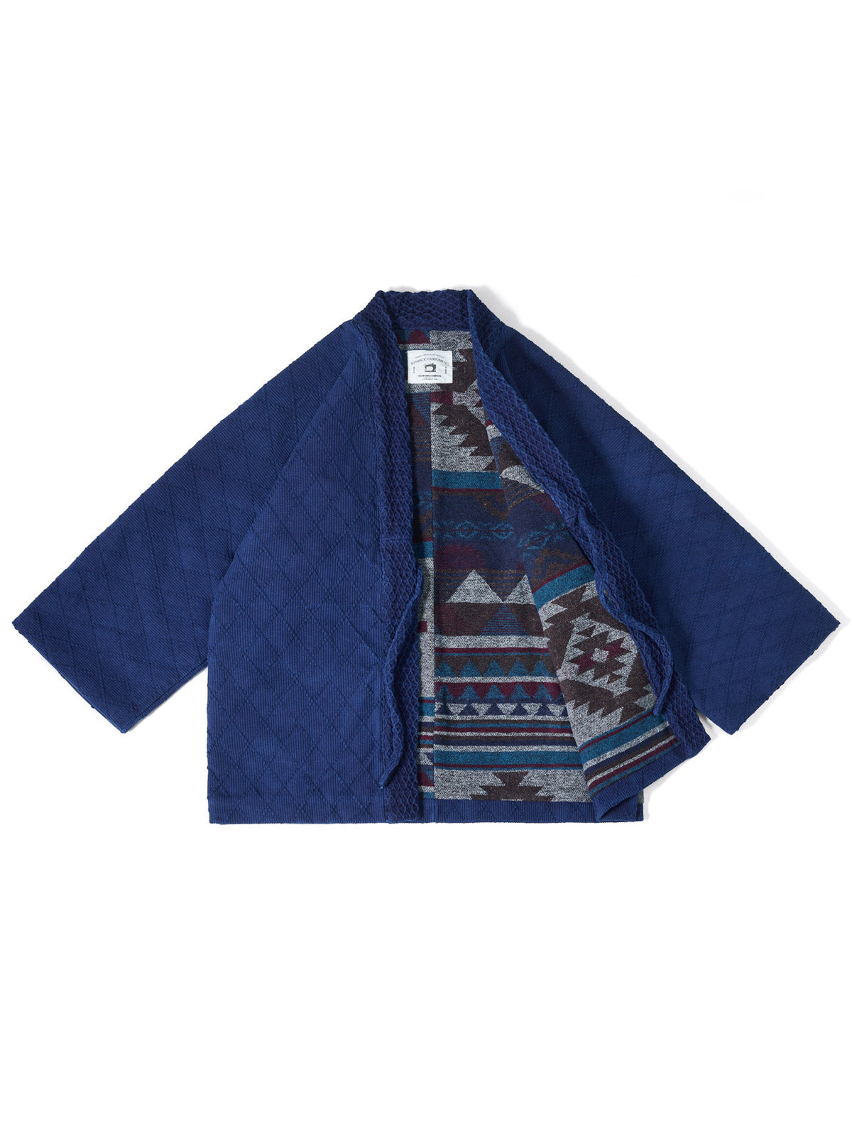 製品画像:
手作り藍染と刺子技法を融合したレトロなデザインのはんてん。伝統的な刺子生地に藍染めの手作業による色彩グラデーションが特徴で、優れた保温性を持つ550gのヘビーウェイト素材。
詳細画像:
藍染めと刺子技法で仕上げられたディテール。民族風の幾何学模様の内衬や、ボタンレスのシンプルなデザインが特徴。重ね着に最適なゆったりシルエット。