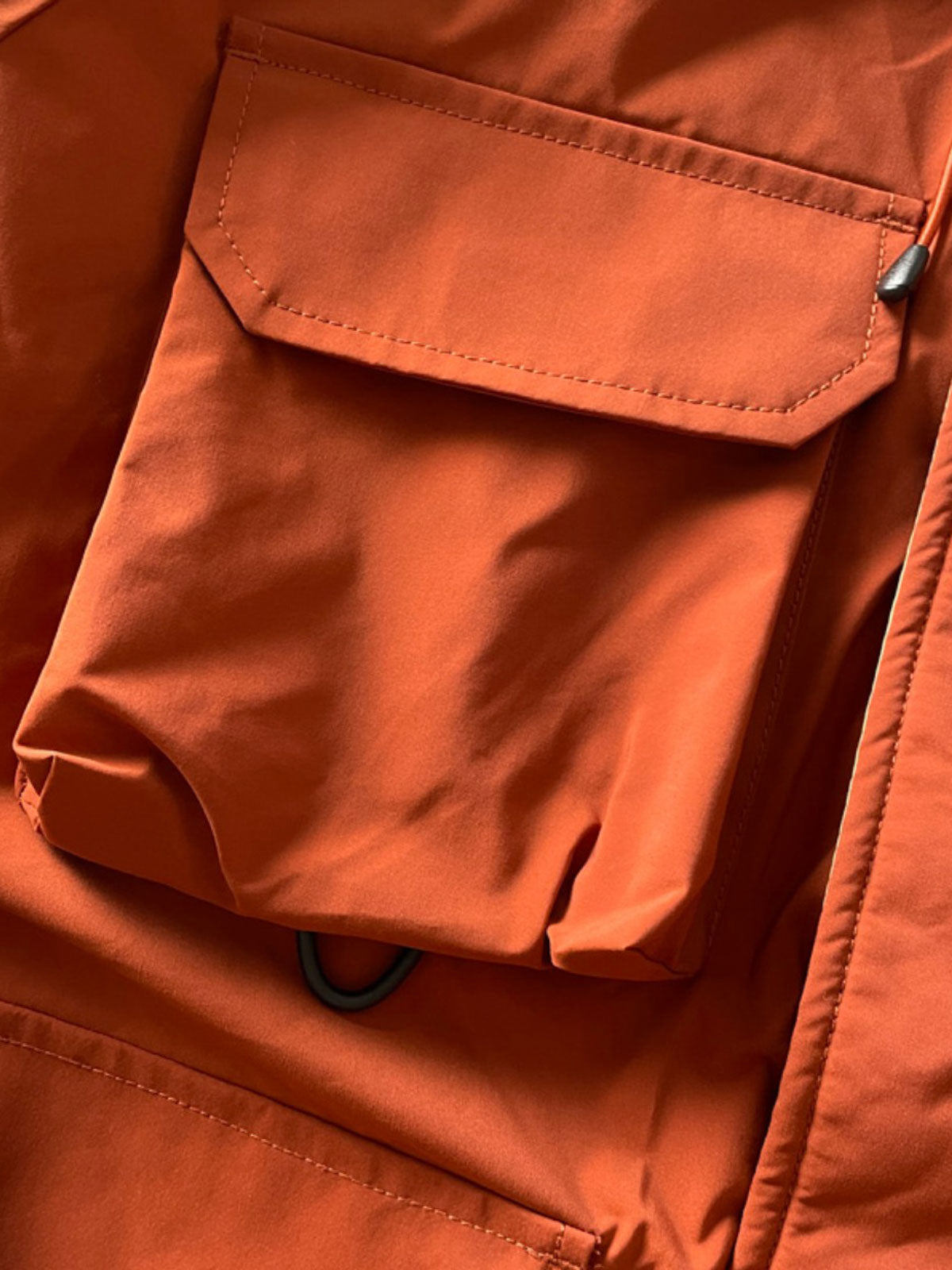 製品画像: 防水ヘビーボア付きアウトドアジャケットの正面画像、防寒性と多機能ポケットが特徴。
詳細画像: 多ポケットと防水素材のディテール画像、アウトドアでの利便性と耐久性を強調。