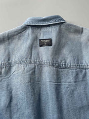 製品画像: 古着風加工の破れ水洗いヴィンテージデニムシャツ正面画像、ヴィンテージ感が際立つ。
詳細画像: ワークポケットと摩耗加工のディテール画像、クラシックな雰囲気を強調。