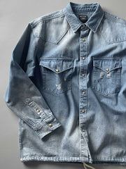 製品画像: 古着風加工の破れ水洗いヴィンテージデニムシャツ正面画像、ヴィンテージ感が際立つ。
詳細画像: ワークポケットと摩耗加工のディテール画像、クラシックな雰囲気を強調。