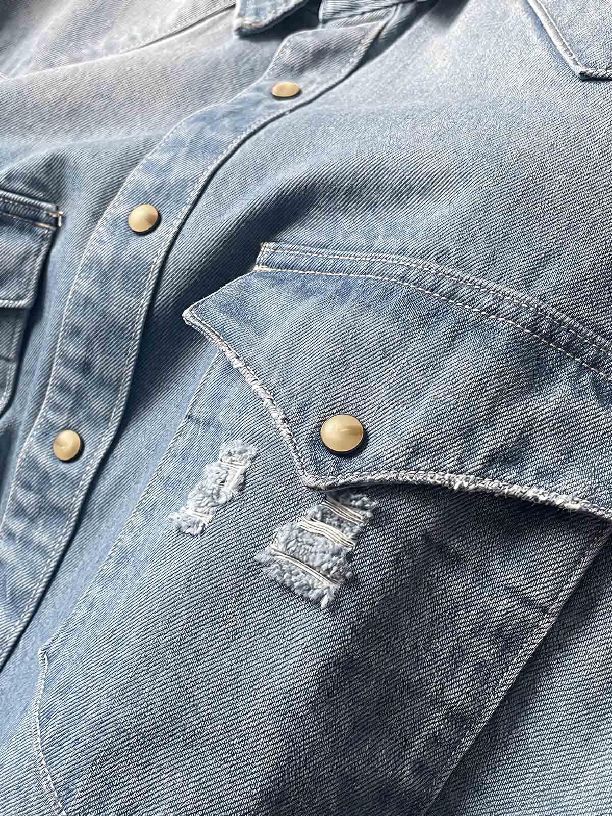 製品画像: 古着風加工の破れ水洗いヴィンテージデニムシャツ正面画像、ヴィンテージ感が際立つ。
詳細画像: ワークポケットと摩耗加工のディテール画像、クラシックな雰囲気を強調。
