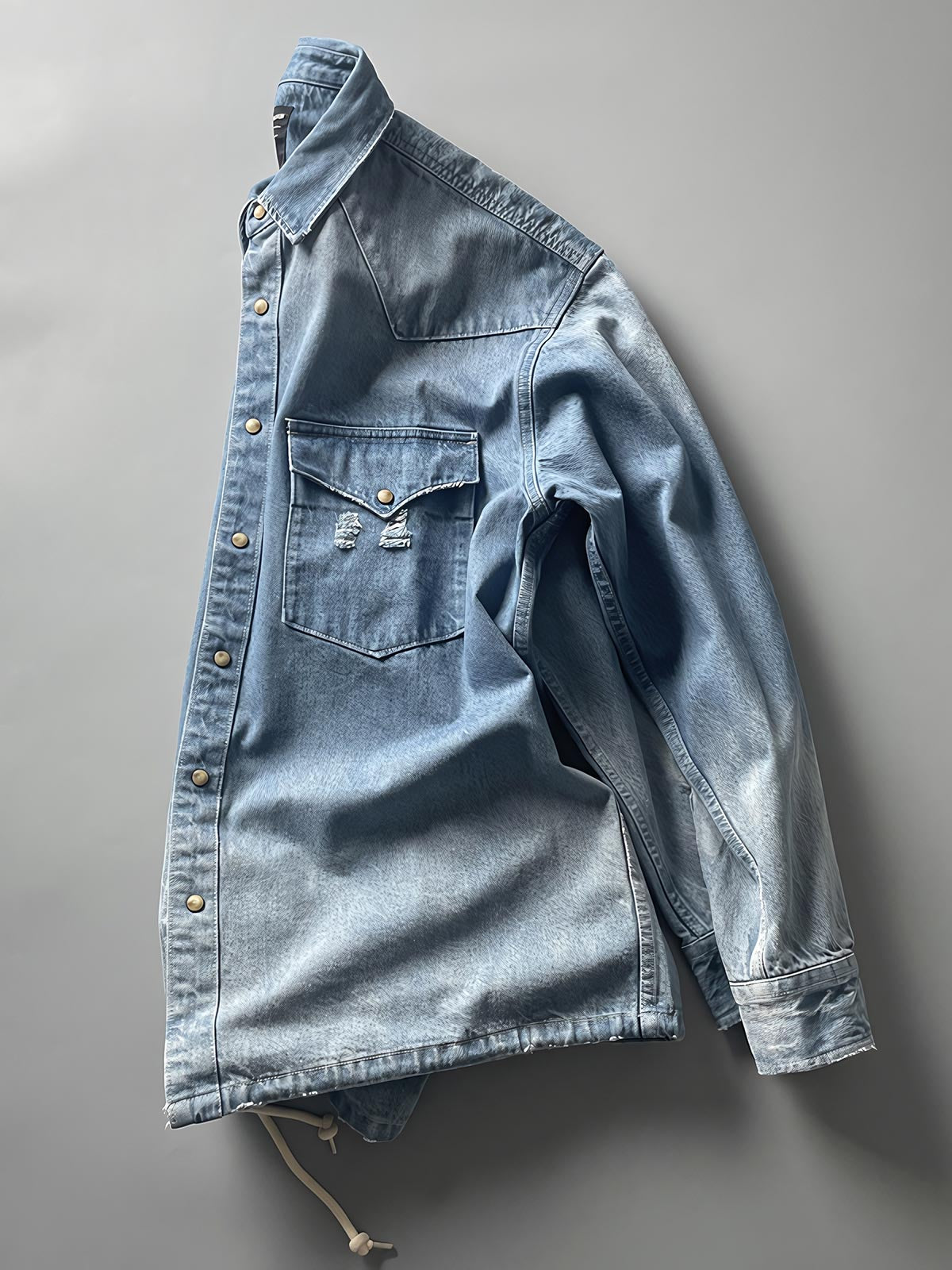 製品画像: 古着風加工の破れ水洗いヴィンテージデニムシャツ正面画像、ヴィンテージ感が際立つ。
詳細画像: ワークポケットと摩耗加工のディテール画像、クラシックな雰囲気を強調。