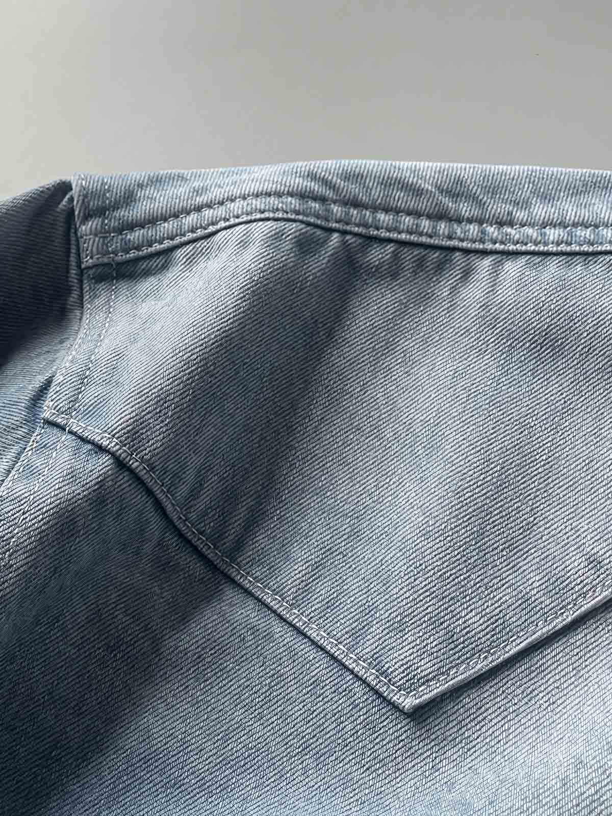 製品画像: 古着風加工の破れ水洗いヴィンテージデニムシャツ正面画像、ヴィンテージ感が際立つ。
詳細画像: ワークポケットと摩耗加工のディテール画像、クラシックな雰囲気を強調。