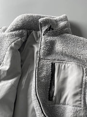 製品画像: ボアフリーススタンドカラージャケットの全体画像、アウトドアやカジュアルスタイルに対応。
詳細画像: 胸元ジッパーポケットのディテール画像、実用性とデザイン性を強調。