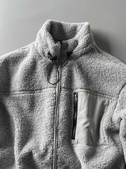 製品画像: ボアフリーススタンドカラージャケットの全体画像、アウトドアやカジュアルスタイルに対応。
詳細画像: 胸元ジッパーポケットのディテール画像、実用性とデザイン性を強調。