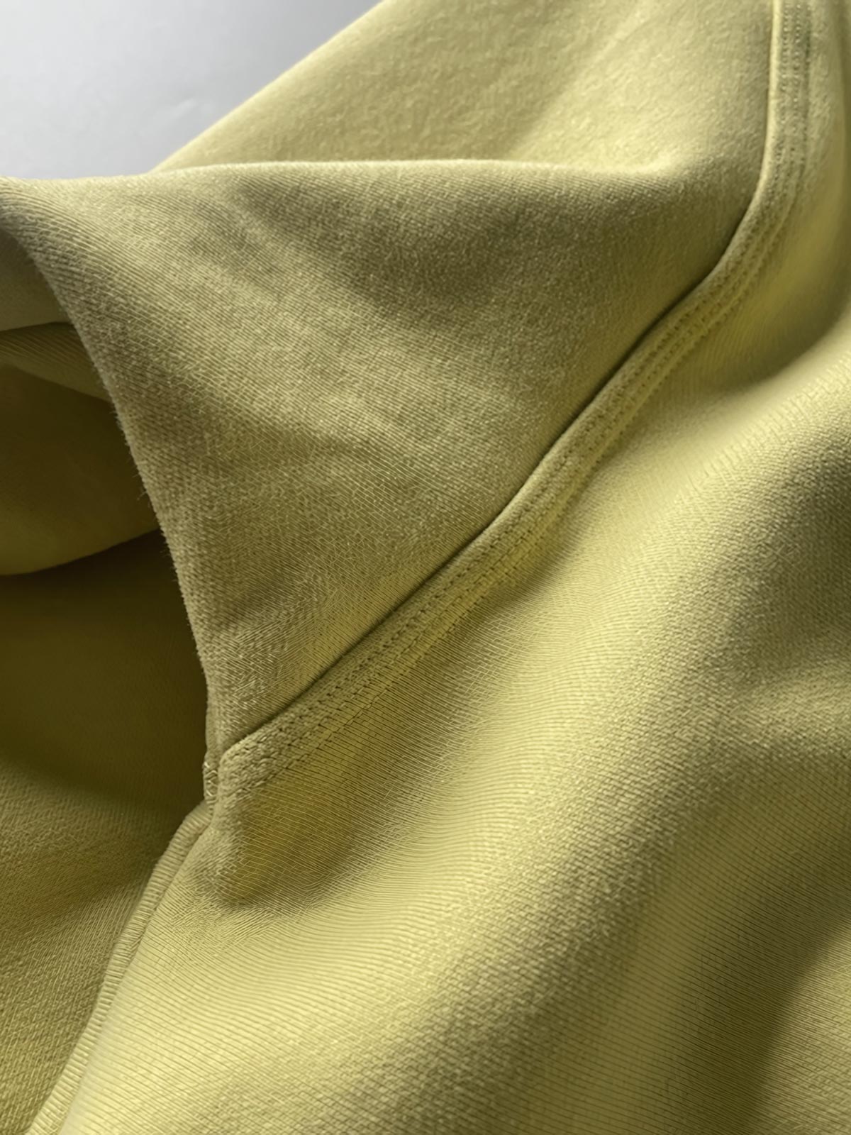 製品画像: ライムイエロー起毛裏起毛スウェットシャツの正面画像、快適で暖かいデザインが特徴。
詳細画像: 胸ポケットと起毛生地のディテール画像、柔らかな質感が際立つ。