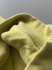 製品画像: ライムイエロー起毛裏起毛スウェットシャツの正面画像、快適で暖かいデザインが特徴。
詳細画像: 胸ポケットと起毛生地のディテール画像、柔らかな質感が際立つ。