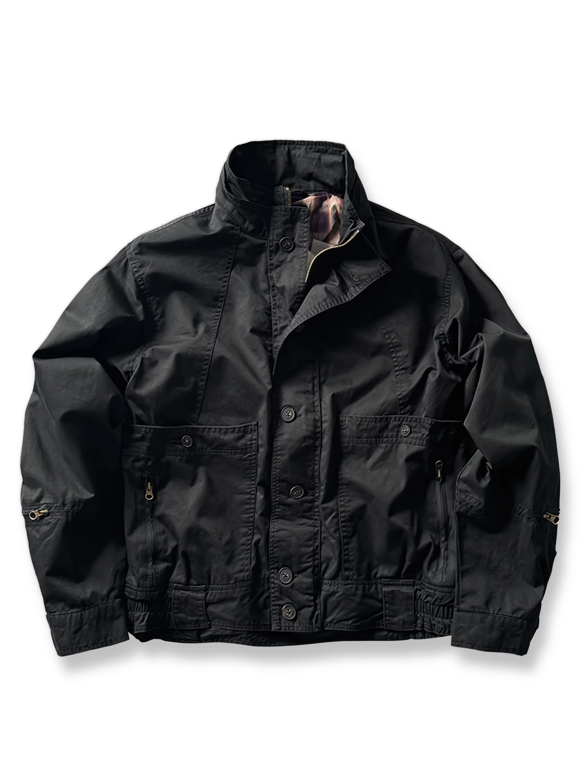 製品画像: オレンジカラーのダブルスタンドカラーワークジャケットの正面画像、実用的でスタイリッシュなデザインが特徴。
詳細画像: 袖部のジッパーポケットとスタンドカラーデザインのディテール画像、ワークスタイルを強調。