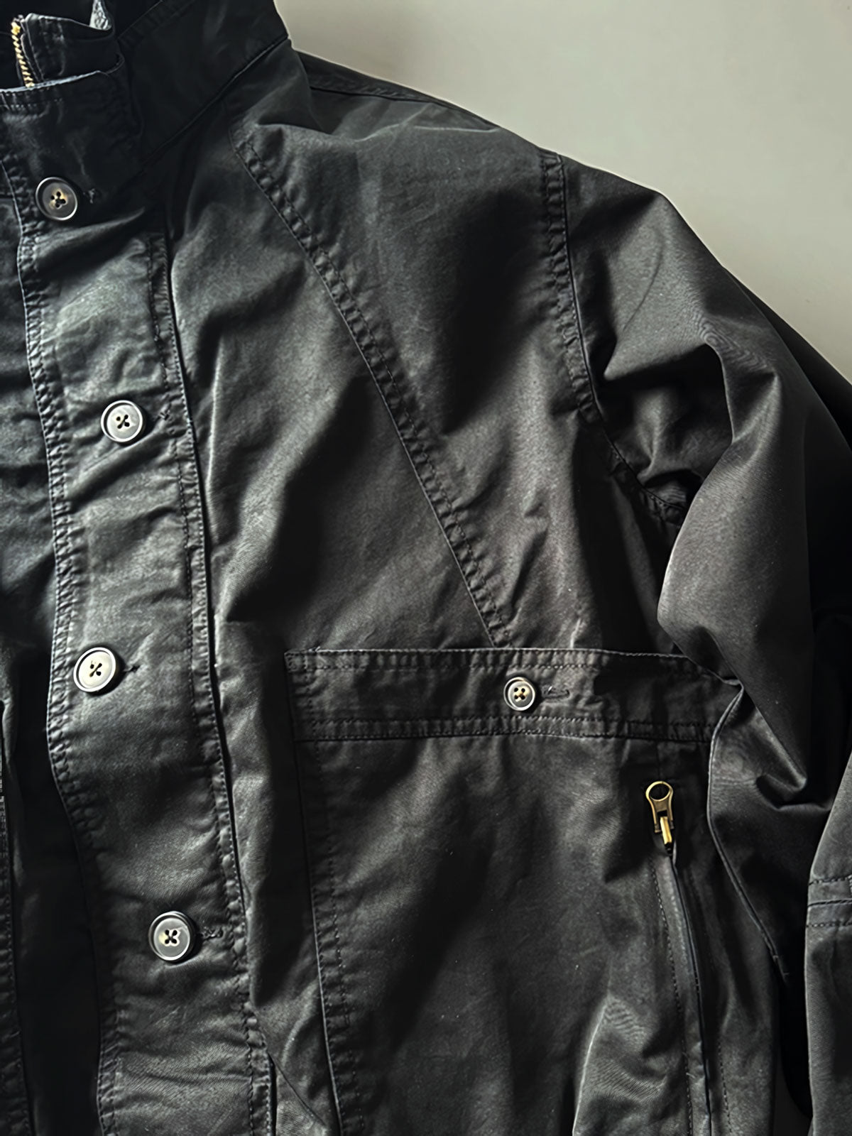 製品画像: オレンジカラーのダブルスタンドカラーワークジャケットの正面画像、実用的でスタイリッシュなデザインが特徴。
詳細画像: 袖部のジッパーポケットとスタンドカラーデザインのディテール画像、ワークスタイルを強調。