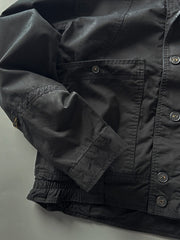 製品画像: オレンジカラーのダブルスタンドカラーワークジャケットの正面画像、実用的でスタイリッシュなデザインが特徴。
詳細画像: 袖部のジッパーポケットとスタンドカラーデザインのディテール画像、ワークスタイルを強調。