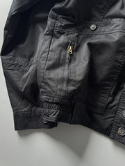 製品画像: オレンジカラーのダブルスタンドカラーワークジャケットの正面画像、実用的でスタイリッシュなデザインが特徴。
詳細画像: 袖部のジッパーポケットとスタンドカラーデザインのディテール画像、ワークスタイルを強調。