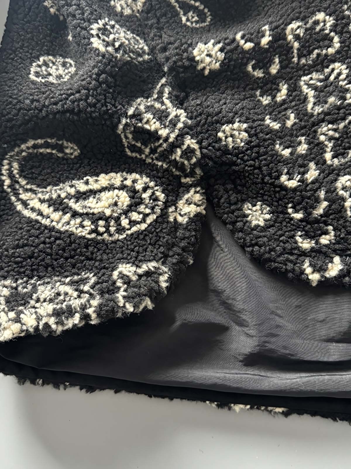 製品画像: ヴィンテージトライバルパターン シープボアシャツの正面画像、トライバルパターンが際立つデザイン。
詳細画像: シープボア素材とトライバルパターンのディテール画像、ヴィンテージ感を強調。