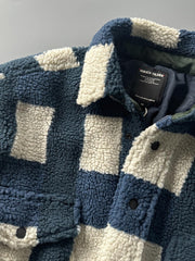 製品画像: ヴィンテージトライバルパターン シープボアシャツの正面画像、トライバルパターンが際立つデザイン。
詳細画像: シープボア素材とトライバルパターンのディテール画像、ヴィンテージ感を強調。