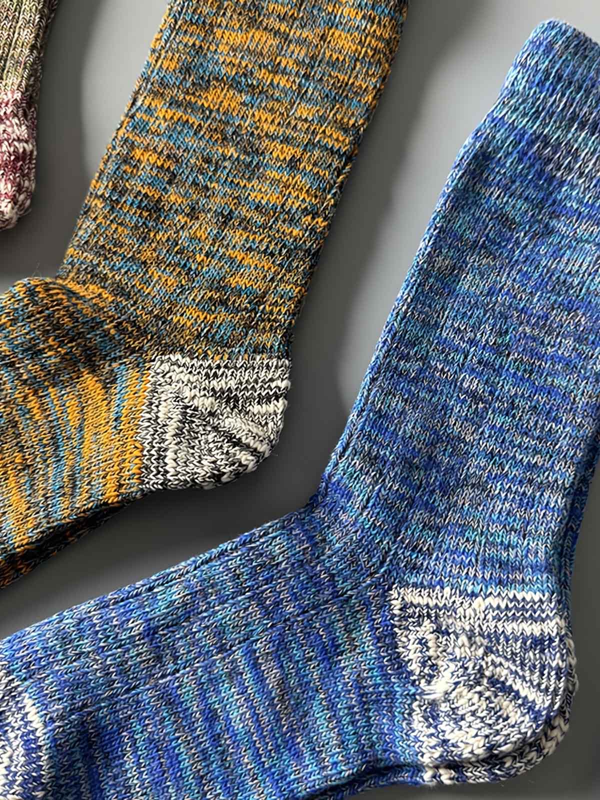 製品画像: カラーミックスヴィンテージロングソックスの5足セット展示、カジュアルで暖かいデザインが特徴。
詳細画像: カラフルなミックス糸で編まれた太糸ソックスのディテール画像、ヴィンテージ感を強調。