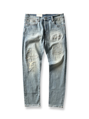 製品画像: ヴィンテージ風破れ加工・パッチ付きデニムパンツ全体画像、ライトブルーのウォッシュ加工とストリート感あふれるデザイン
詳細画像: 破れ加工、パッチディテールのクローズアップ、ヴィンテージ風デニムパンツのディテール、セルビッジデザインが特徴