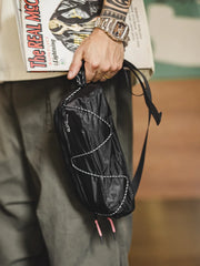 オールブラックのリップストップナイロン製ミニバッグ、ダブルヘッドジップとナイロンコードアクセント付き