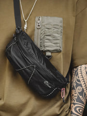 オールブラックのリップストップナイロン製ミニバッグ、ダブルヘッドジップとナイロンコードアクセント付き