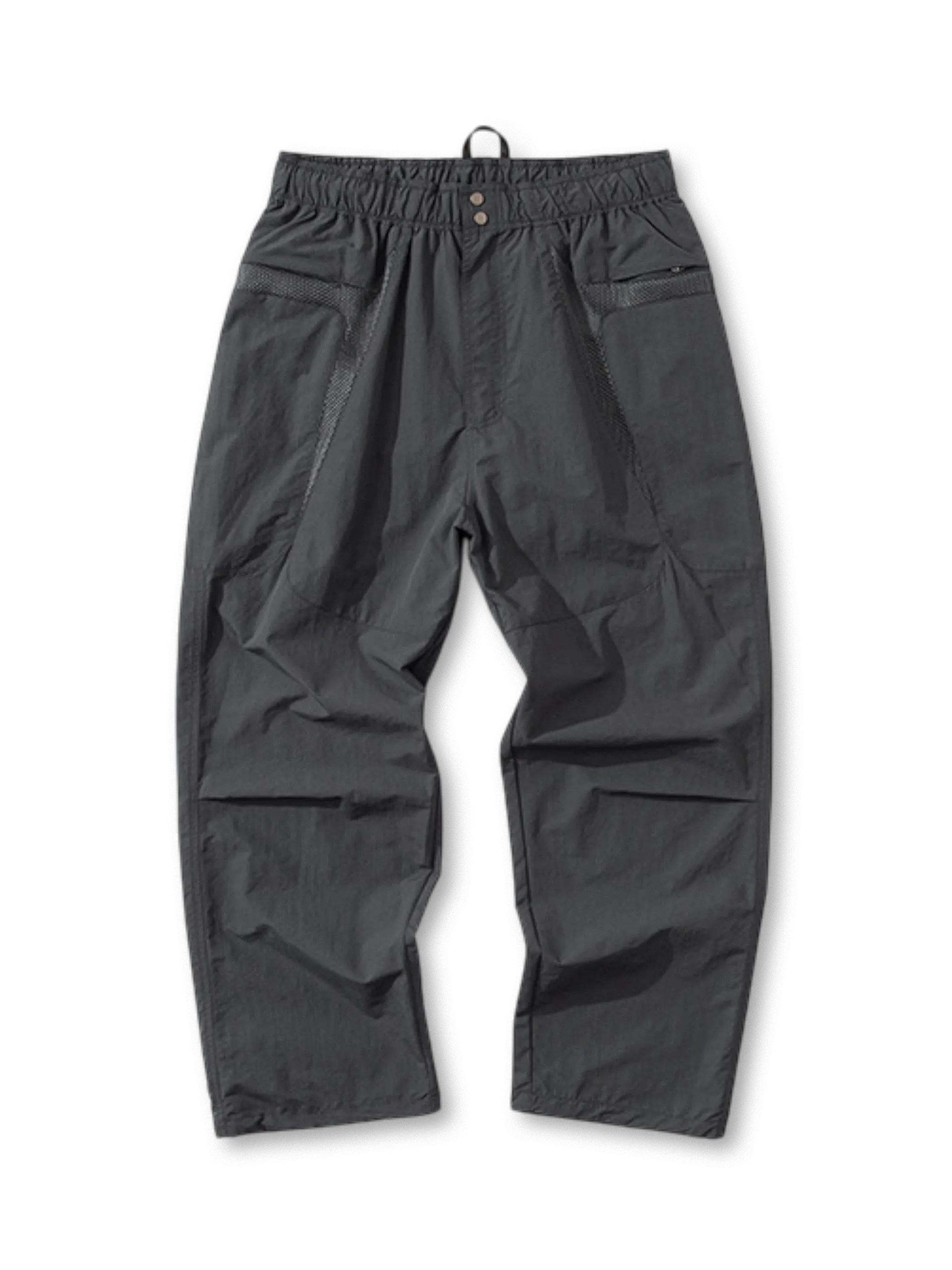 配色切り替えしが施されたナイロンパンツ全体。ウエストはゴム仕様で、ポケットや膝部分のデザインが特徴的