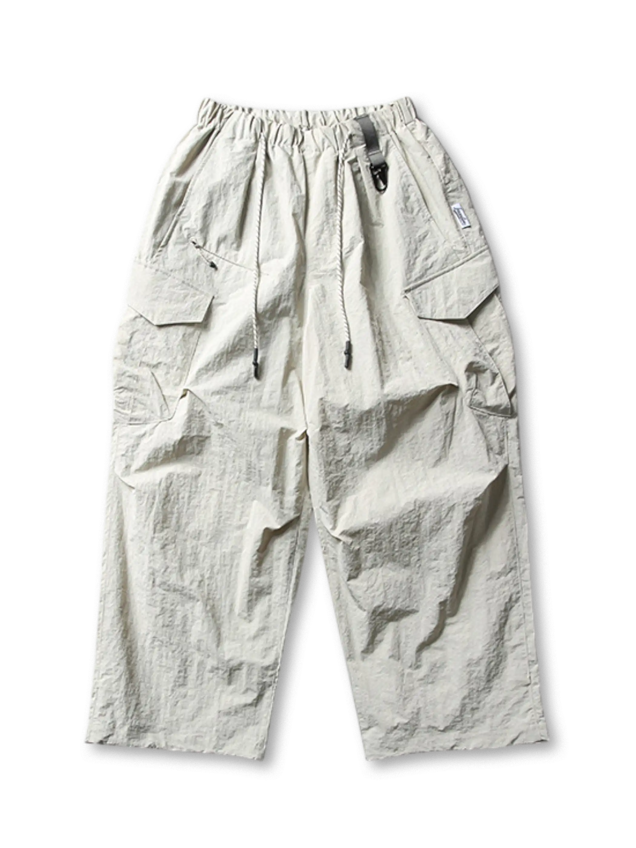 超ワイドシルエットのエアリーパラシュートパンツ。撥水・防風・速乾性に優れたナイロン生地。ゴムとドローコードのウエスト、調節可能な脚口アジャスター付き。アウトドアやストリートに最適なユニセックスデザイン。